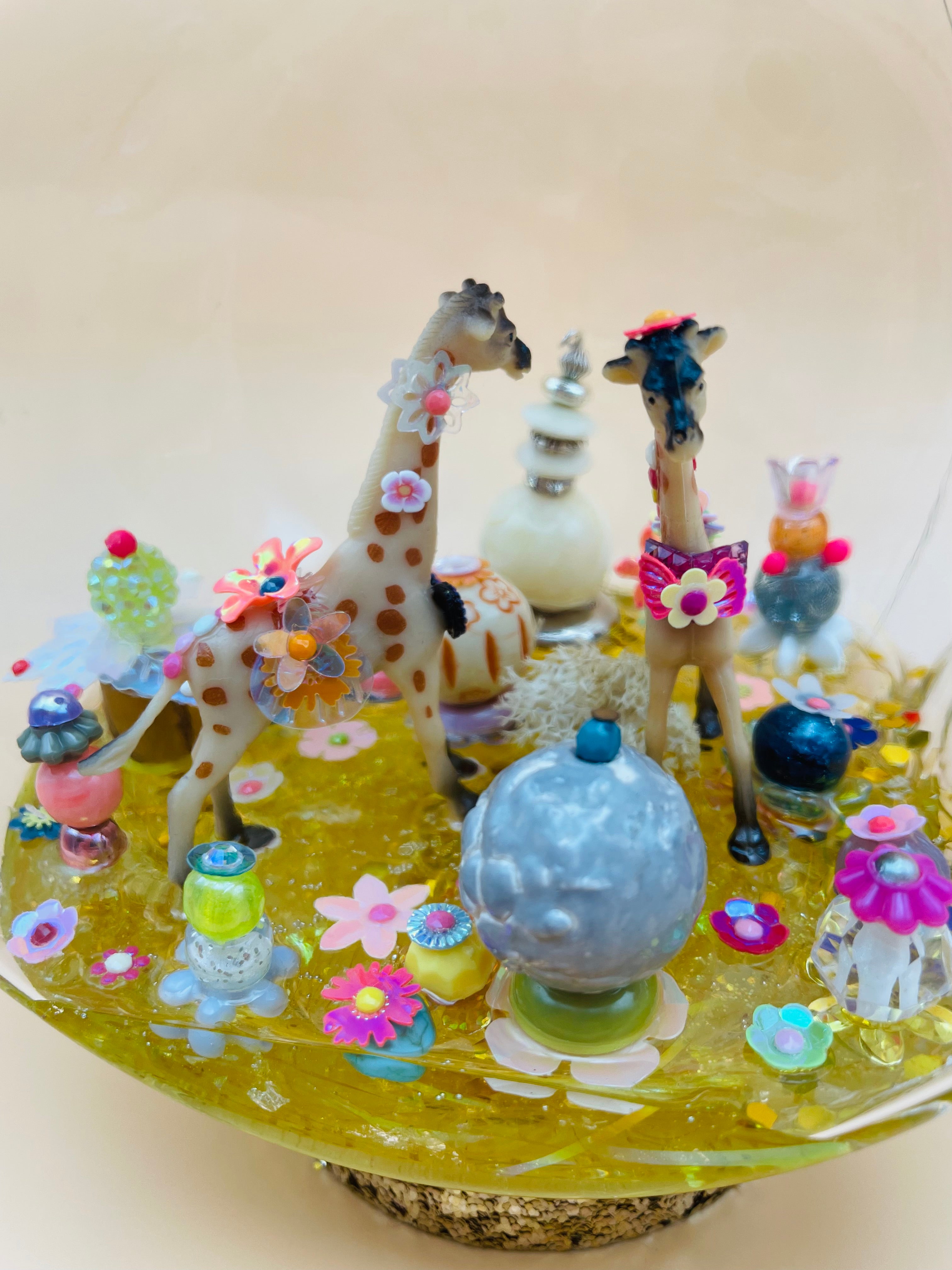 Détail du jardin imaginaire avec animaux totems Girafes en résine et perles