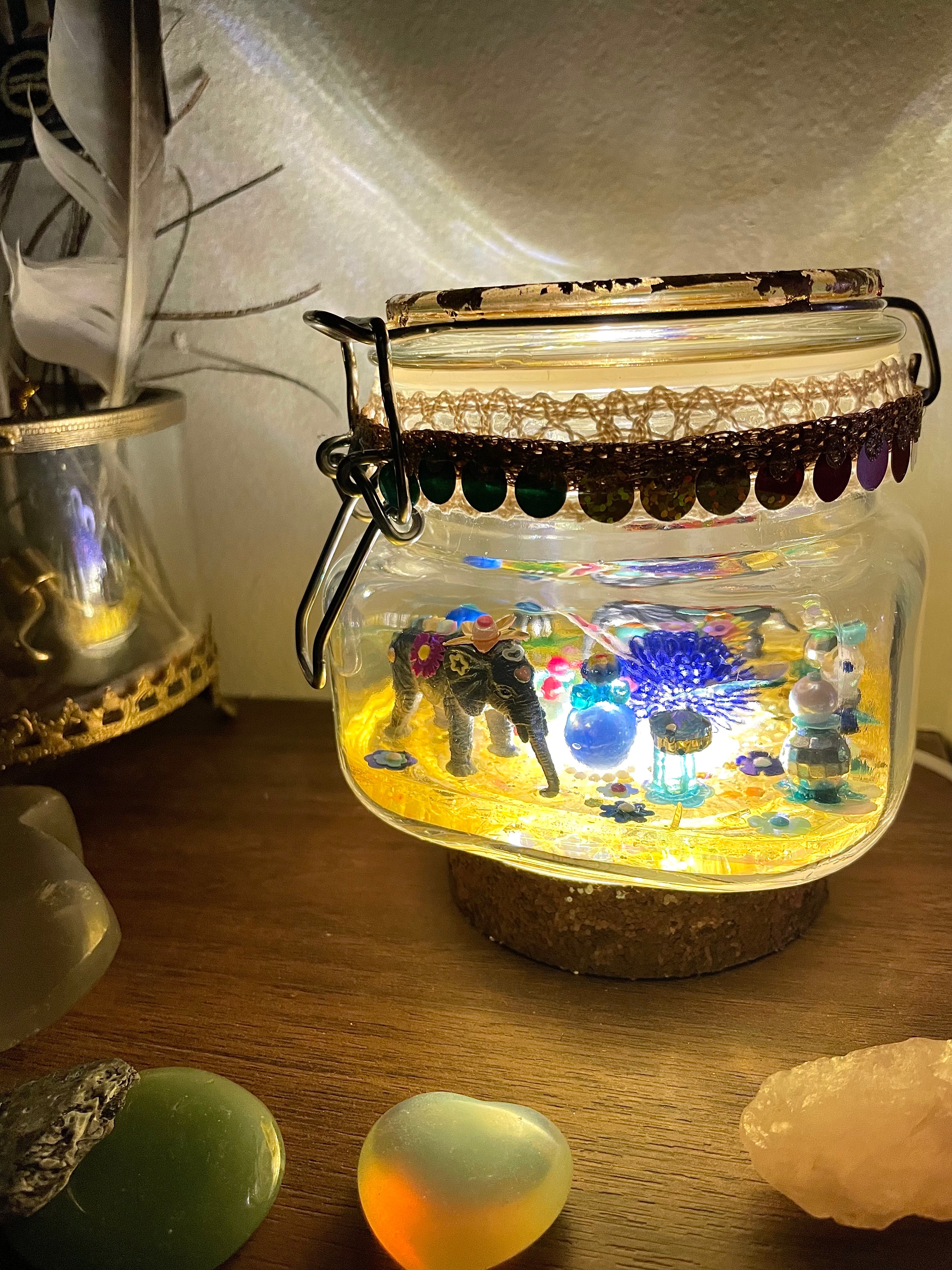 Veilleuse artistique à poser avec animaux totems éléphants et socle en résine pailletée allumée dans une chambre